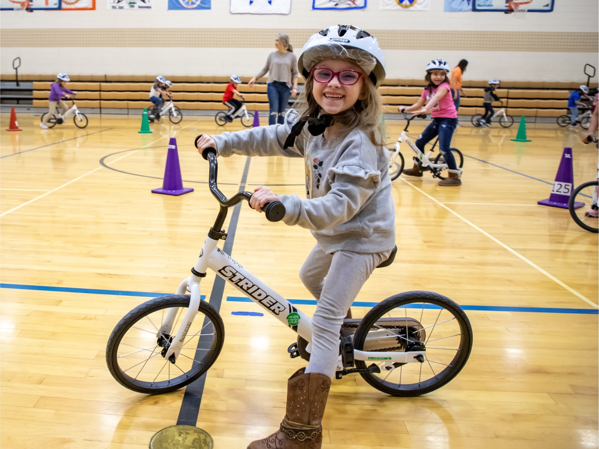 Girl on bike in gym classroom